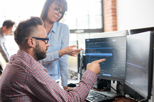 Man with glasses pointing to computer screen