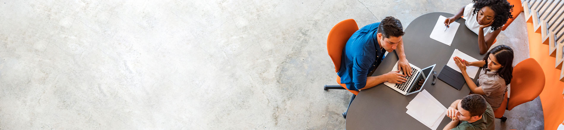 5 people sitting on orange chairs around a table