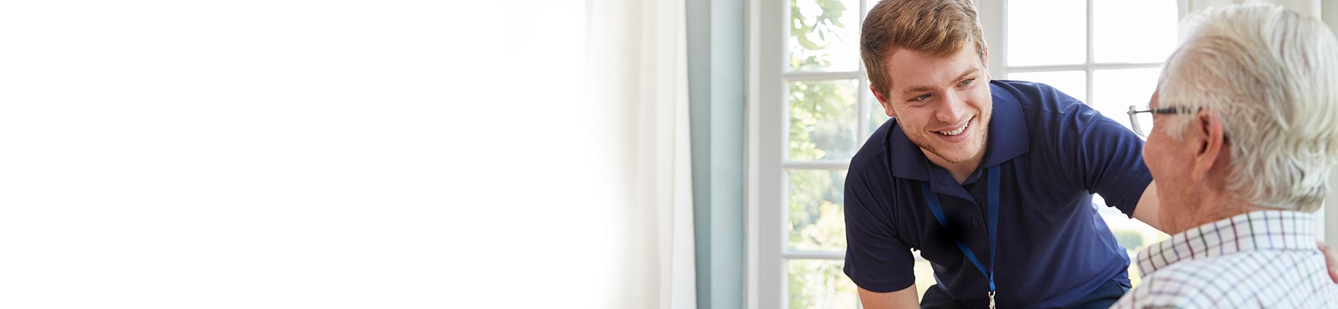 Male carer looking after eldery man Male carer looking after eldery man