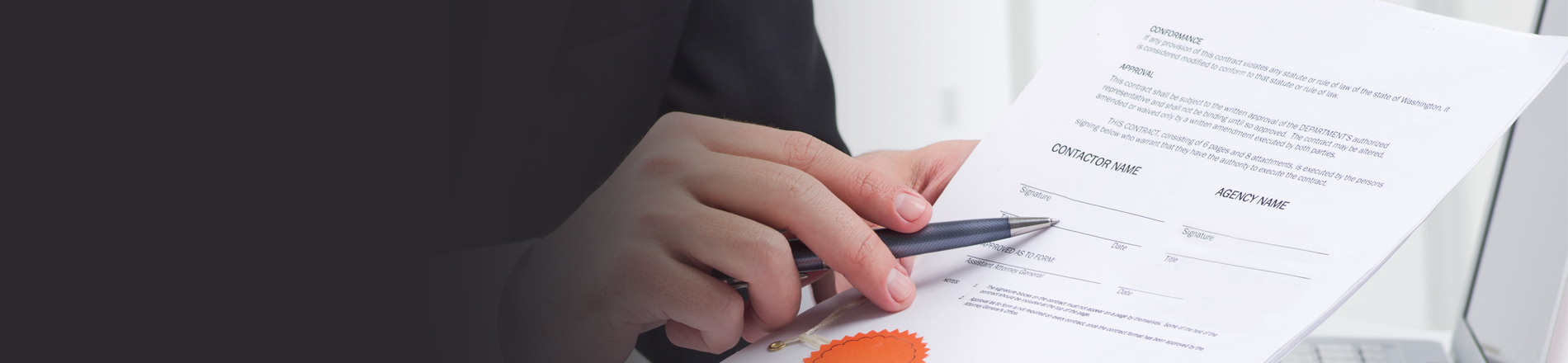 Man holding pen pointing to contract